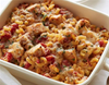 Casserole dish with cavatappi pasta, cubed chicken, red peppers, zucchini, marinara, topped with cheese and breadcrumbs

