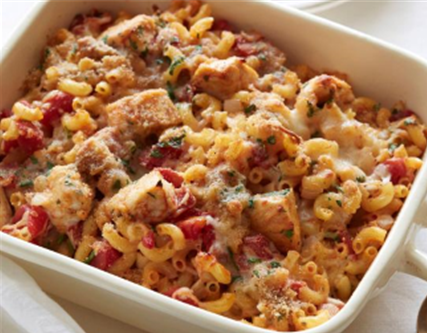 Casserole dish with cavatappi pasta, cubed chicken, red peppers, zucchini, marinara, topped with cheese and breadcrumbs
