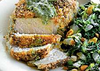 Crispy seasoned porkchops with pesto and a side of collard greens with golden raisins