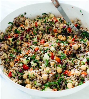 Bowl of quinoa tossed with chickpeas, fresh parsley, diced red bell pepper and cucumbers 