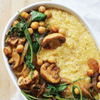 A white baking dish filled with creamy mushrooms, spinach, and polenta