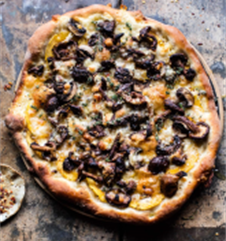Homemade pizza with cheese, delicata squash, and mushrooms